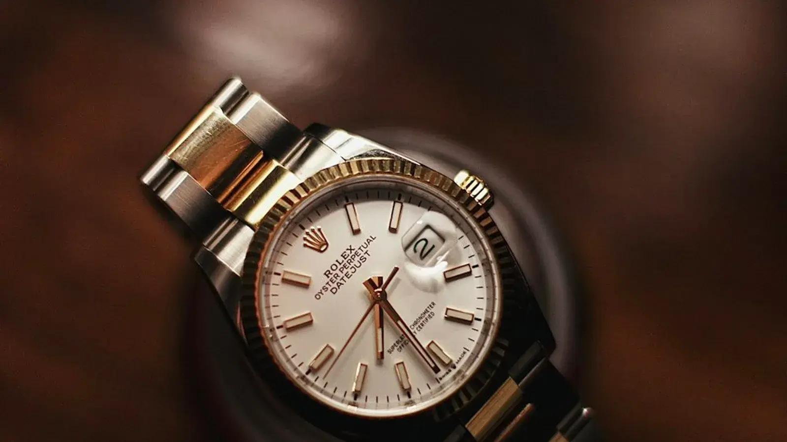 Two-tone Rolex Datejust with a fluted bezel resting on dark leather